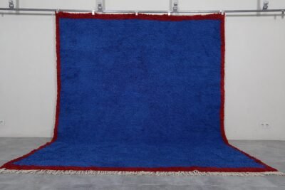 Authentic Moroccan Blue Beni Ourain rug hand-knotted by skilled Berber women artisans using 100% natural sheep wool. This striking wool carpet features a deep, vibrant blue color inspired by the Mediterranean Sea and Atlantic Ocean. Its traditional Berber design and luxurious texture make it perfect for enhancing living rooms, bedrooms, or walls with cultural and artistic elegance.