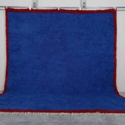 Authentic Moroccan Blue Beni Ourain rug hand-knotted by skilled Berber women artisans using 100% natural sheep wool. This striking wool carpet features a deep, vibrant blue color inspired by the Mediterranean Sea and Atlantic Ocean. Its traditional Berber design and luxurious texture make it perfect for enhancing living rooms, bedrooms, or walls with cultural and artistic elegance.