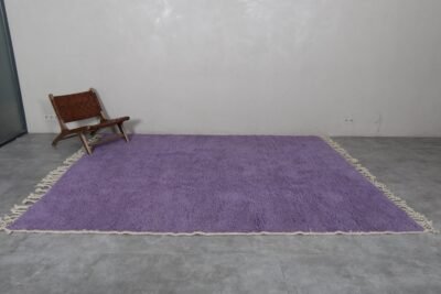 thick natural wool fibers in an iris purple Moroccan rug. Berber knotting details visible, showcasing luxury craftsmanship and deep texture.