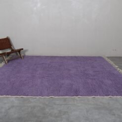 thick natural wool fibers in an iris purple Moroccan rug. Berber knotting details visible, showcasing luxury craftsmanship and deep texture.