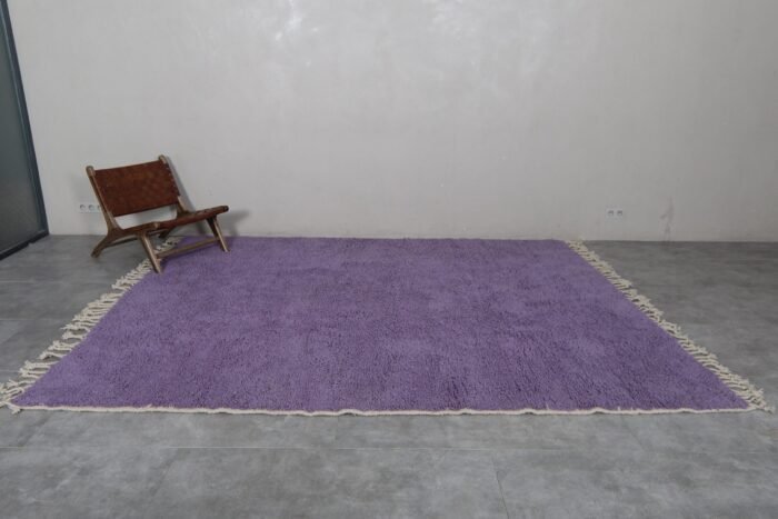 thick natural wool fibers in an iris purple Moroccan rug. Berber knotting details visible, showcasing luxury craftsmanship and deep texture.