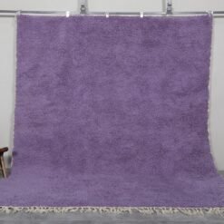 Handmade Moroccan Berber rug in rich iris purple color, crafted with 100% natural wool by Atlas Mountain artisans. This elegant Beni Ourain rug adds depth, warmth, and artistic flair to modern interiors. Ideal for stylish living rooms, bedrooms, or statement entryways.