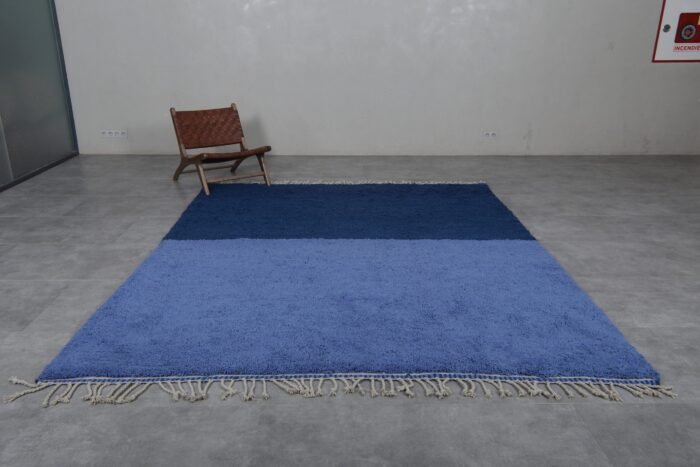 Moroccan rug in cobalt and light blue tones, showing the wool texture and traditional Berber handweaving.