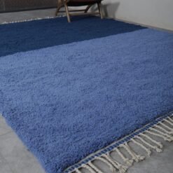 Close-up of fringe on light and cobalt Moroccan rug, showing handmade knots and fine Berber wool finishing.