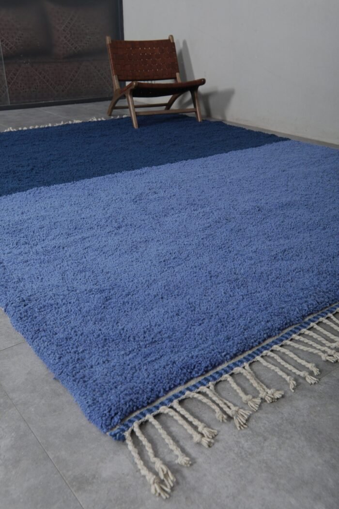 Close-up of fringe on light and cobalt Moroccan rug, showing handmade knots and fine Berber wool finishing.