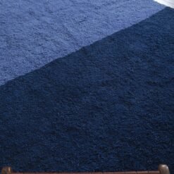 Detailed macro image of soft lamb wool texture in a handmade Moroccan rug featuring cobalt and light blue shades.