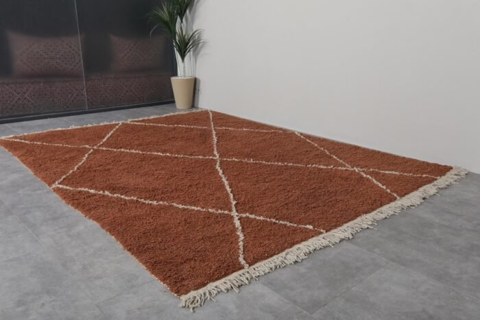 terracotta Moroccan wool rug featuring an ivory trellis design, showcasing the dense, plush wool texture and artisan hand-knotting.