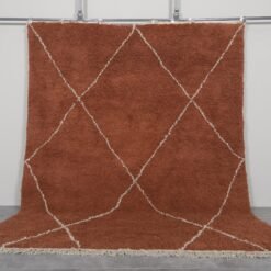 Handmade Moroccan rug with a warm terracotta background and soft ivory trellis pattern, woven by Berber artisans using 100% natural lamb wool in the classic Beni Ourain style.