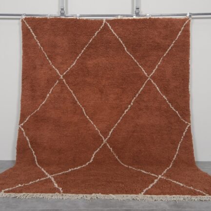 Handmade Moroccan rug with a warm terracotta background and soft ivory trellis pattern, woven by Berber artisans using 100% natural lamb wool in the classic Beni Ourain style.
