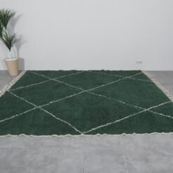 solid green Moroccan wool rug, showing soft high-pile texture and minimalist Berber craftsmanship suitable for living rooms or bedrooms.
