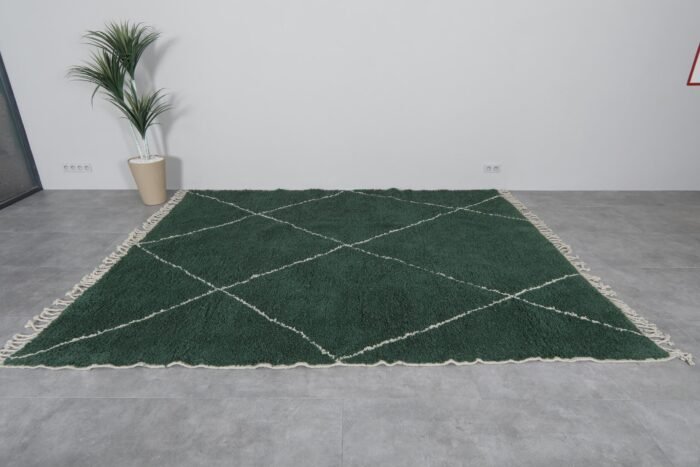 solid green Moroccan wool rug, showing soft high-pile texture and minimalist Berber craftsmanship suitable for living rooms or bedrooms.