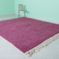 Left angle of handmade plum Moroccan wool rug with tribal Berber style.