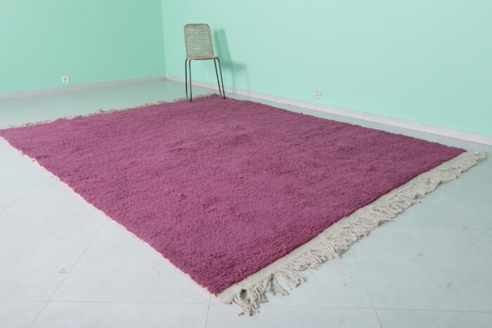 Left angle of handmade plum Moroccan wool rug with tribal Berber style.
