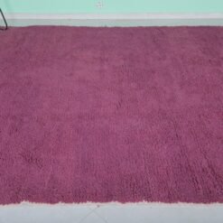 Top-down view of Moroccan plum rug showing solid wool surface and texture.