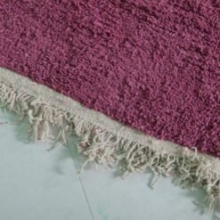 Fringe detail of handmade Moroccan plum Beni Ourain rug in deep purple wool.