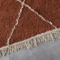 fringe and finishing detail on terracotta and ivory Moroccan rug, emphasizing handmade quality and Berber craftsmanship.
