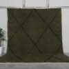 Handmade Moroccan rug with deep dark green base and bold black trellis pattern, crafted from 100% natural lamb wool by Berber artisans using traditional Beni Ourain weaving.