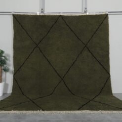 Handmade Moroccan rug with deep dark green base and bold black trellis pattern, crafted from 100% natural lamb wool by Berber artisans using traditional Beni Ourain weaving.