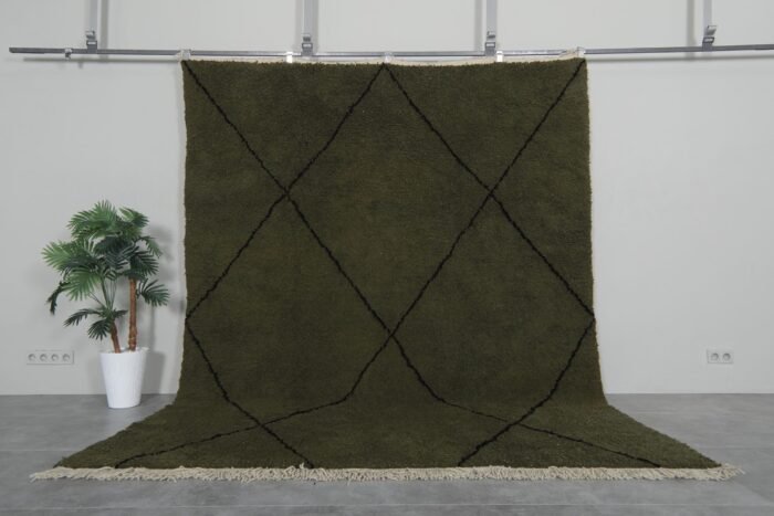 Handmade Moroccan rug with deep dark green base and bold black trellis pattern, crafted from 100% natural lamb wool by Berber artisans using traditional Beni Ourain weaving.