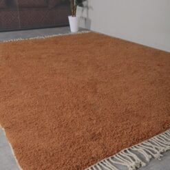 fringed edges on a handmade Moroccan rust wool rug, emphasizing fine hand-knotted details