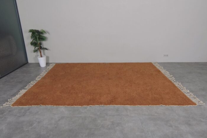 handwoven Moroccan rust wool rug, showcasing rich color and plush texture by Berber artisans.