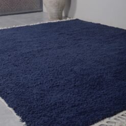 Hand-knotted wool fibers of the cobalt blue Moroccan rug, emphasizing the artisanal quality and plush texture created by Berber women weavers.