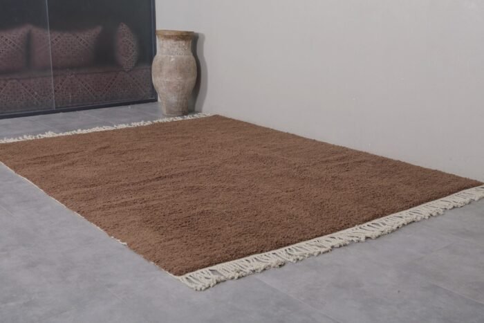 solid brown Moroccan rug, showcasing traditional weaving technique and soft wool pile made for comfort and durability.