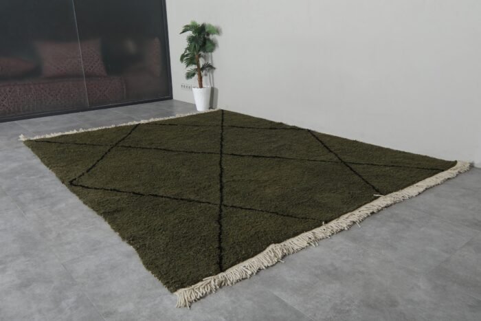custom-sized dark green and black Moroccan rug, emphasizing the soft wool pile and striking trellis design.