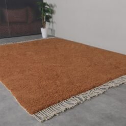 rustic Moroccan wool rug in deep rust hue, featuring classic Beni Ourain tribal designs.