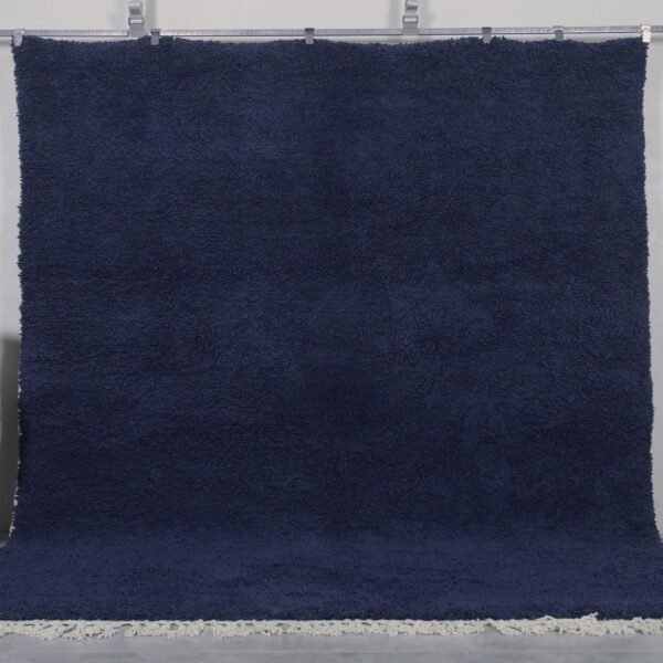 Authentic handmade Moroccan cobalt blue Beni Ourain rug crafted from 100% natural wool by Berber artisans. This vibrant solid blue rug features a thick, plush pile and traditional hand-knotted weaving, perfect for living rooms, bedrooms, or modern boho interiors.