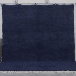 Authentic handmade Moroccan cobalt blue Beni Ourain rug crafted from 100% natural wool by Berber artisans. This vibrant solid blue rug features a thick, plush pile and traditional hand-knotted weaving, perfect for living rooms, bedrooms, or modern boho interiors.