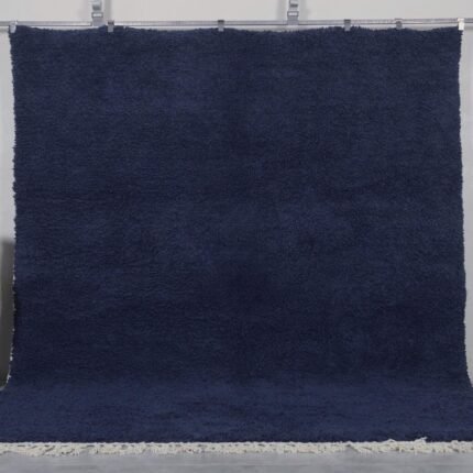 Authentic handmade Moroccan cobalt blue Beni Ourain rug crafted from 100% natural wool by Berber artisans. This vibrant solid blue rug features a thick, plush pile and traditional hand-knotted weaving, perfect for living rooms, bedrooms, or modern boho interiors.