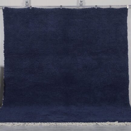 Authentic handmade Moroccan cobalt blue Beni Ourain rug crafted from 100% natural wool by Berber artisans. This vibrant solid blue rug features a thick, plush pile and traditional hand-knotted weaving, perfect for living rooms, bedrooms, or modern boho interiors.