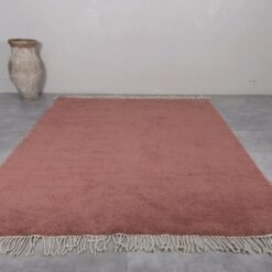 handmade Moroccan rust brown Beni Ourain rug, highlighting the deep earthy tones and dense wool pile woven by skilled Berber artisans in the Atlas Mountains.