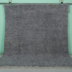 Handmade Moroccan gray wool rug with traditional Beni Ourain tribal patterns, crafted by skilled Berber artisans from 100% natural lamb wool, featuring a soft, durable pile perfect for living rooms and bedrooms with modern or rustic decor