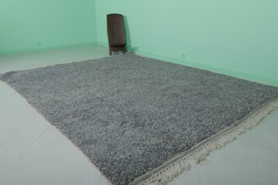 handmade Moroccan gray wool Beni Ourain rug showing the thick, plush wool texture and authentic tribal geometric designs, made by Berber women artisans in the Atlas Mountains