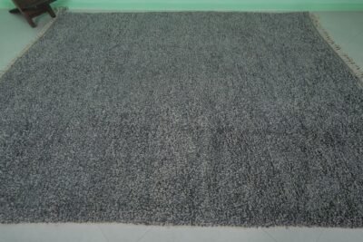 Overhead view of an authentic handmade Moroccan gray wool rug with traditional Beni Ourain tribal designs, emphasizing the thick wool pile and expert hand-knotting by Berber artisans.