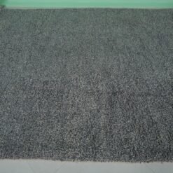 Overhead view of an authentic handmade Moroccan gray wool rug with traditional Beni Ourain tribal designs, emphasizing the thick wool pile and expert hand-knotting by Berber artisans.