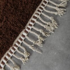 fringes on Moroccan wool rug in brown and ivory, highlighting handmade finish and traditional Berber weaving.