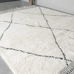 custom-sized ivory and black Moroccan rug, emphasizing the soft wool pile and striking geometric pattern.
