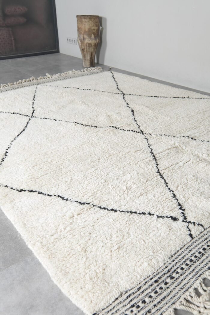 custom-sized ivory and black Moroccan rug, emphasizing the soft wool pile and striking geometric pattern.