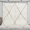 Hand-knotted Moroccan rug featuring an ivory base with bold black trellis pattern, crafted from 100% natural lamb wool by skilled Berber artisans in Morocco.