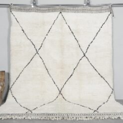Hand-knotted Moroccan rug featuring an ivory base with bold black trellis pattern, crafted from 100% natural lamb wool by skilled Berber artisans in Morocco.