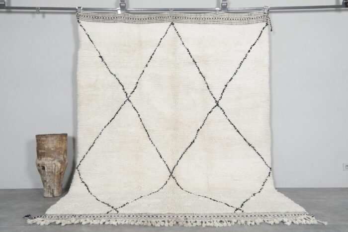 Hand-knotted Moroccan rug featuring an ivory base with bold black trellis pattern, crafted from 100% natural lamb wool by skilled Berber artisans in Morocco.