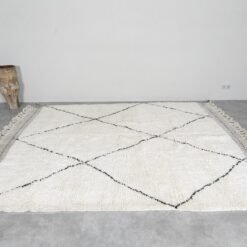 Moroccan wool rug in ivory and black trellis design, illustrating quality weaving and thickness.