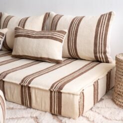 Side view of long Moroccan floor cushion in cream with brown stripes on wooden floor