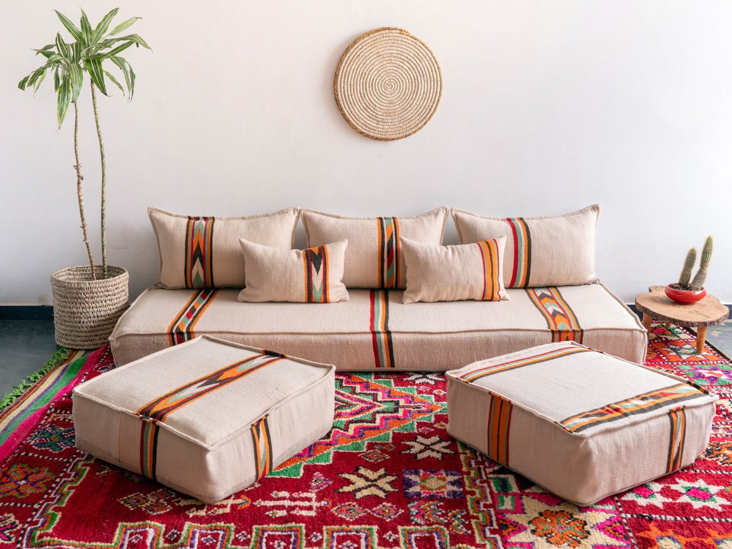 Handmade Moroccan floor couch set in cream wool with orange and black embroidered patterns, unstuffed cushions with zippered covers