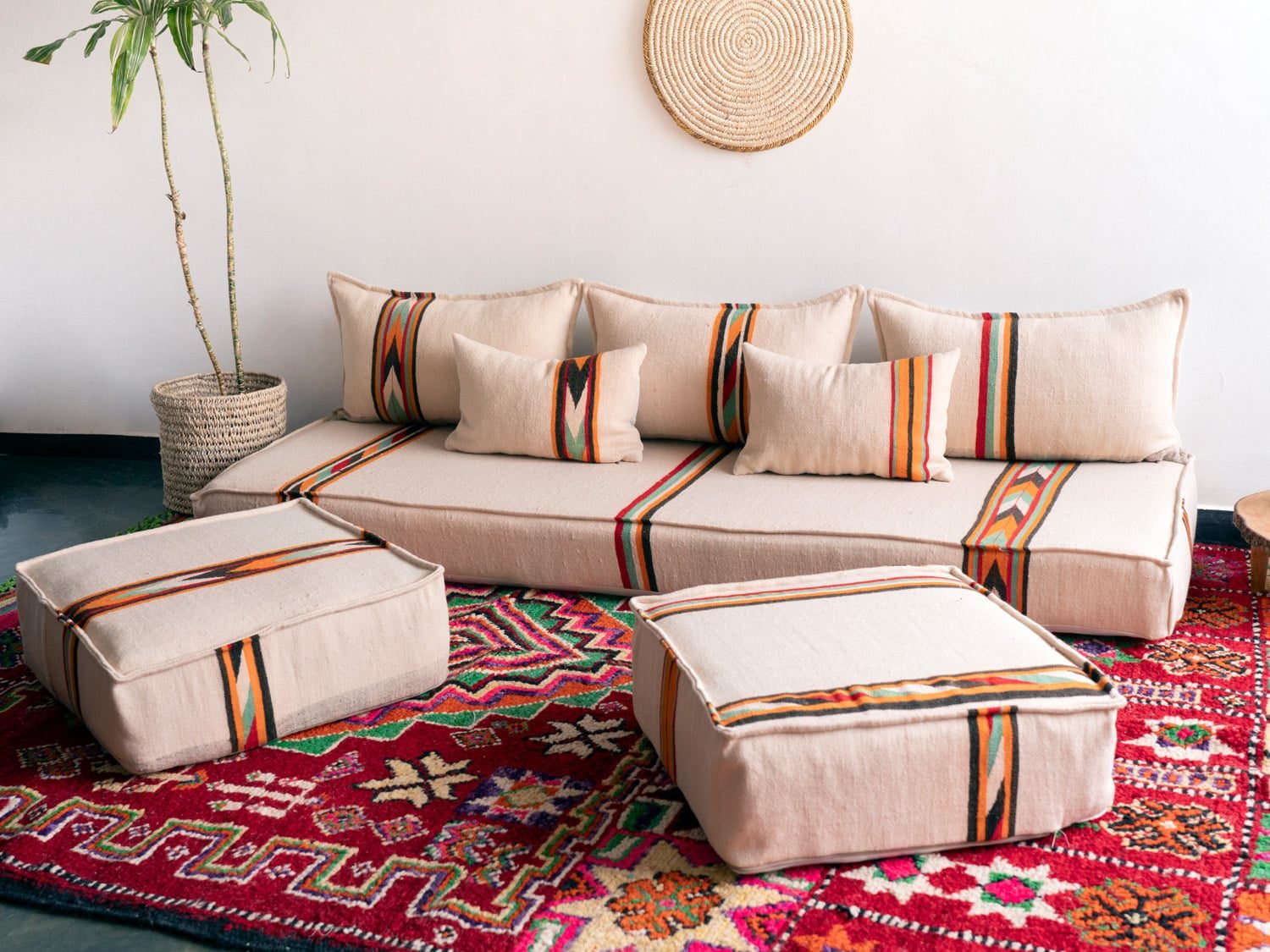 Bohemian living room featuring Moroccan floor couch set with cream and orange-black cushions