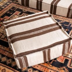 Artisan hand-finishing ivory wool cushion with brown embroidery