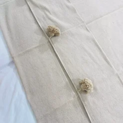 Close-up of size label and cotton material tag on beige Moroccan blanket
